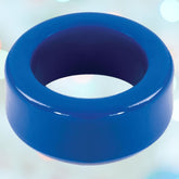 A close-up of the Titanmen Stretch-to-Fit Blue Cock Ring by Doc Johnson, showcasing its glossy solid blue design against a gently blurred, multicolored background. The ring features a smooth, rounded shape and offers stretch-to-fit versatility.